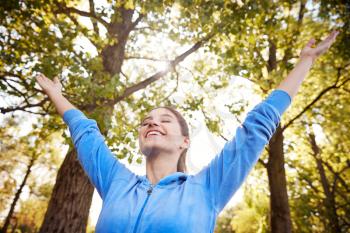 Woman Outdoors In Fitness Clothing Stretching Arms And Celebrating Nature