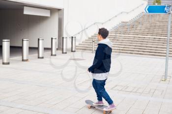 Young Woman Riding On Skateboard Through City Underpass