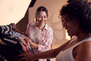 Stylist Discussing Wardrobe With Female Photographer On Fashion Shoot In Studio