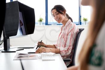 Female Retoucher Working At Computer Using Graphics Tablet In Post Production Company