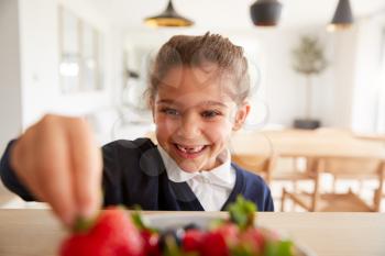 Mischievous Girl Wearing School Uniform Taking Strawberry From Kitchen Counter