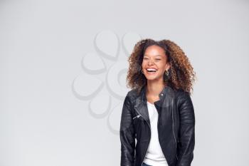 Waist Up Studio Shot Of Happy Young Woman Wearing Leather Jacket Laughing Off Camera