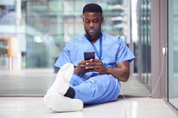 Male Medical Worker In Hospital Addicted To Using Mobile Phone At Work