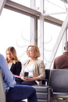 Businesswomen Sitting In Airport Departure Working On Laptop And Drinking Coffee