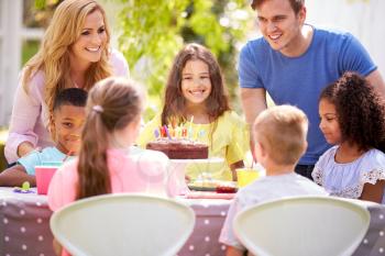 Parents And Daughter Celebrating Birthday With Friends Having Party In Garden At Home