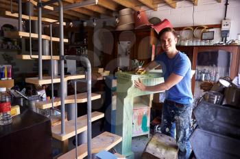Portrait Of Man In Workshop Upcycling And Working On Fire Surround