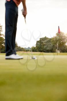Close Up Of Female Golfer Putting Ball On Green