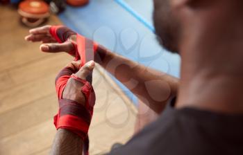 Close Up Of Male Boxer Training In Gym Putting Wraps On Hands