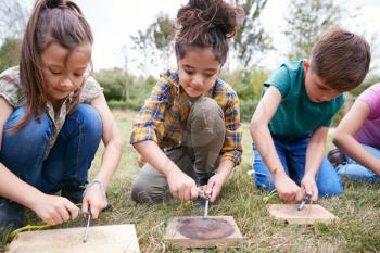 Group Of Children On Outdoor Camping Trip Learning How To Make Fire