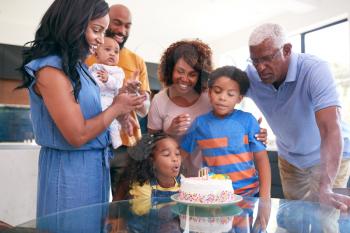 Multi-Generation African American Family Celebrating Daughters Birthday At Home Together
