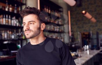 Portrait Of Confident Male Owner Of Restaurant Bar Standing By Counter