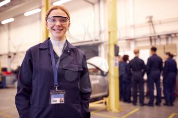 Portrait Of Female Student With Safety Glasses Studying For Auto Mechanic Apprenticeship At College