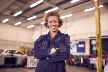 Portrait Of Female Tutor With Safety Glasses Teaching Auto Mechanic Apprenticeship At College