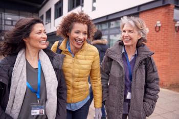 Group Of Smiling Female Mature Students Walking Outside College Building