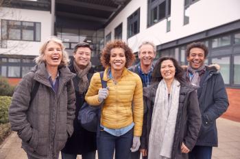 Portrait Of Group Of Smiling Mature Students Standing Outside College Building