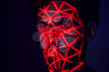 Facial Recognition Technology Concept As Man Has Red Grid Projected Onto Face In Studio