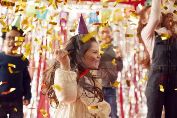 Group Of Children In Party Hats Celebrating At Birthday Party With Streamers And Gold Confetti