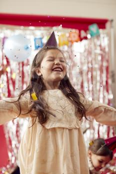 Girl In Party Hat Celebrating At Birthday Party With Glitter And Gold Confetti