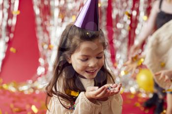 Girl In Party Hat Celebrating At Birthday Party With Glitter And Gold Confetti