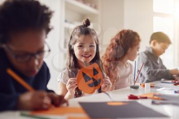 Portrait Of Children At Home With Friends Having Fun Making Halloween Decorations Together