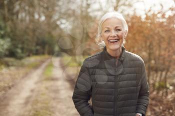 Portrait Of Smiling Senior Woman On Walk In Countryside Exercising During Covid 19 Lockdown