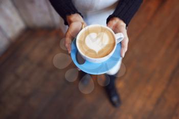 Close Up Of Waitress In Coffee Shop Holding Cup With Heart Design Poured Into Milk
