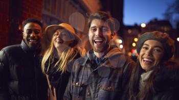 Portrait Of Group Of Friends In City Outdoors On Night Out Together