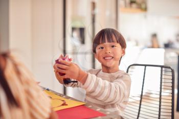Portrait Of Young Asian Boy Painting Picture And Having Fun Doing Craft On Table At Home