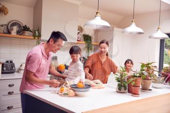 Asian Family Unpacking Local Food In Zero Waste Packaging From Bag In Kitchen At Home