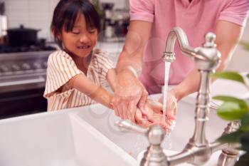 Asian Father Helping Daughter To Wash Hands With Soap At Home To Stop Infection In Health Pandemic