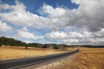 Road to the Grand Canyon. Autumn yellow fields and the magnificent cloudy sky
