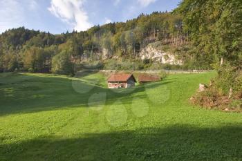  The Alpine meadow, rural small houses and the autumn sun