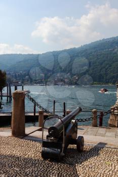 The ancient gun decorates quay in beautiful well-groomed park on island Izola Bella