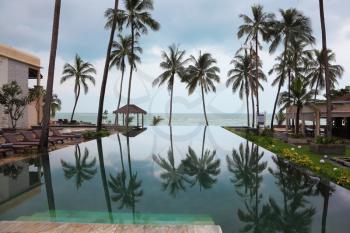 Mirror-like surface of water. Smooth water pools on the beach, the Andaman Sea, reflects the high scenic palm
