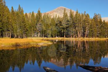 A quiet lake, surrounded by woods, in the mountains of Yosemite Park. Early autumn morning
