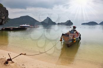 The famous Thai Longtail boat mooring anchor in the sand. The picturesque sandy beach on an ocean island. Thailand
