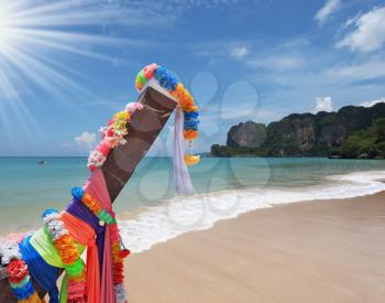 Beautifully decorated with colored silks Native boat Longtail on a sandy beach in Thailand