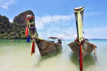 Beautiful, ornate antique two boats Longtail on a beach in Thailand
