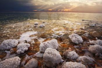 Coast of the Dead Sea in Israel in a spring thunder-storm. The coastal stones covered by salty adjournment