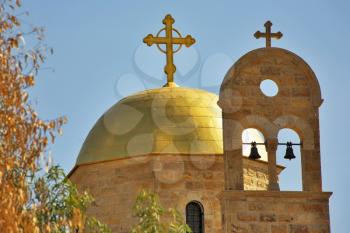 The dome of orthodox church shined by the sun and a small belltower near to it