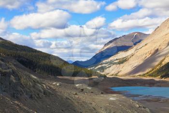 Brilliant turquoise Bow Lake and the picturesque triangular mountain. Early autumn in the Rocky Mountains of Canada.