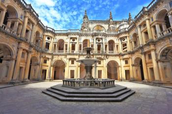 Beautifully preserved castle - palace of the Templars. Courtyard surrounded by galleries. In the center - a fountain with a pool in the shape of a cross. Portugal, Tomar