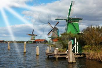 Windmlls and channels  in museum village in Holland. Good autumn day
