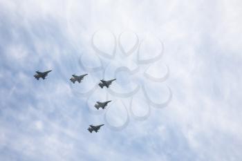 The squadron of warplanes flying in the cloudy sky
