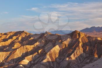 The well-known site of Death Valley in California - the Zabriski-point. Picturesque hills of pink, yellow and chocolate shades on a sunset
