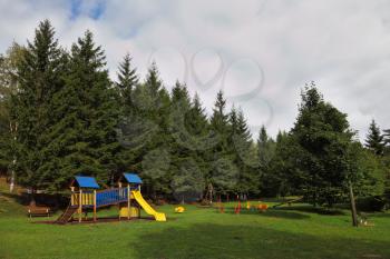 Park for children at the forest resort in the Alps. Beginning of autumn