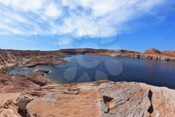 Magnificent Lake Powell. The small bay in the middle of the desert rock of red-orange striped sandstone. Photo taken fisheye lens