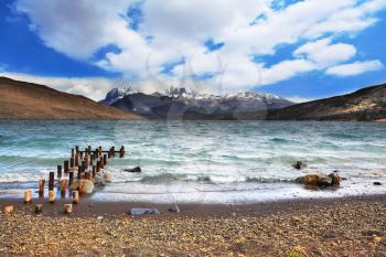 Crazy wind Patagonia. The scenic Lake Laguna Azul and a boat dock in national park Torres del Paine, Chile