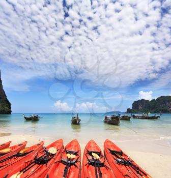 Red modern boats- canoes and boats classic Longtail awaiting tourists. Thailand, the southern islands