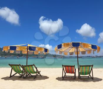 Beach paradise on the Krabi, Thailand. Colorful parasols and deck chairs are waiting for convenient travel